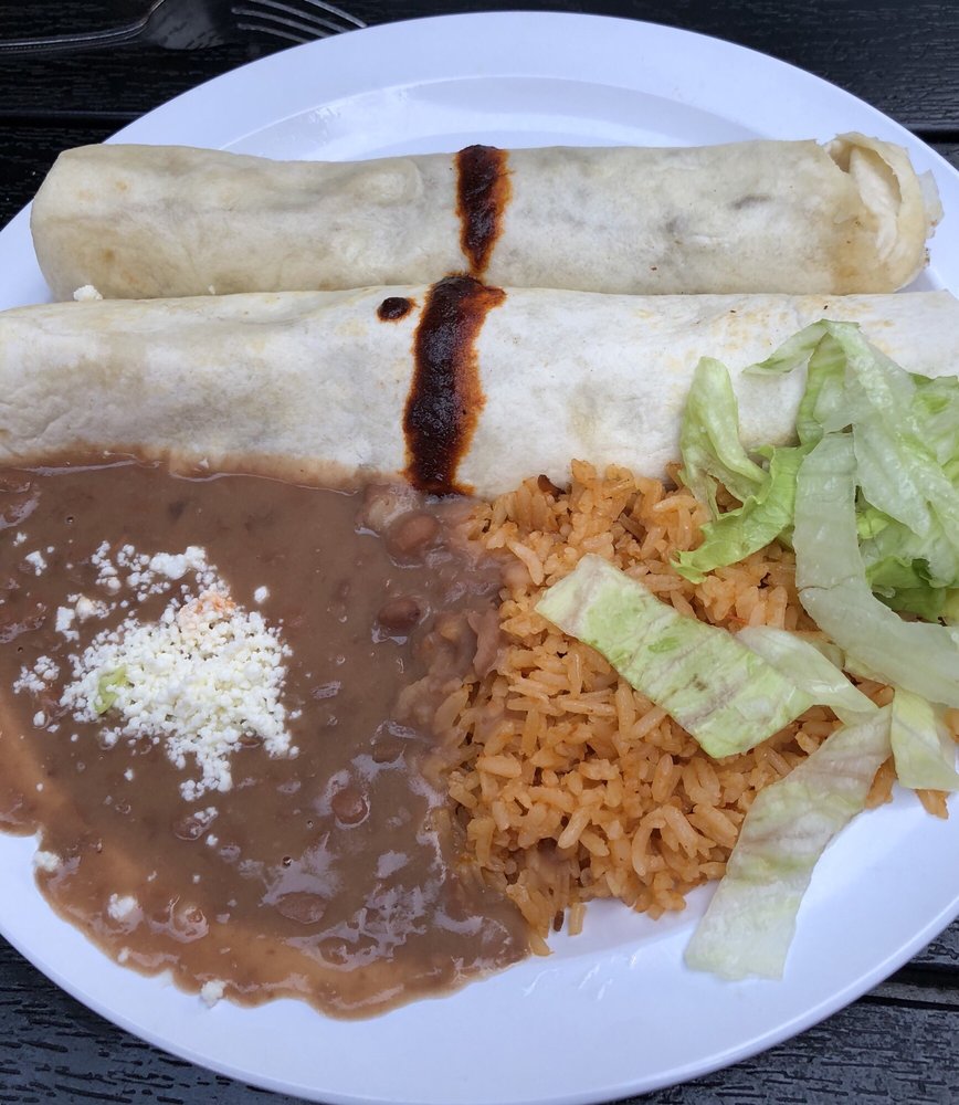Enchiladas with rice, refried beans, crema and lettuce