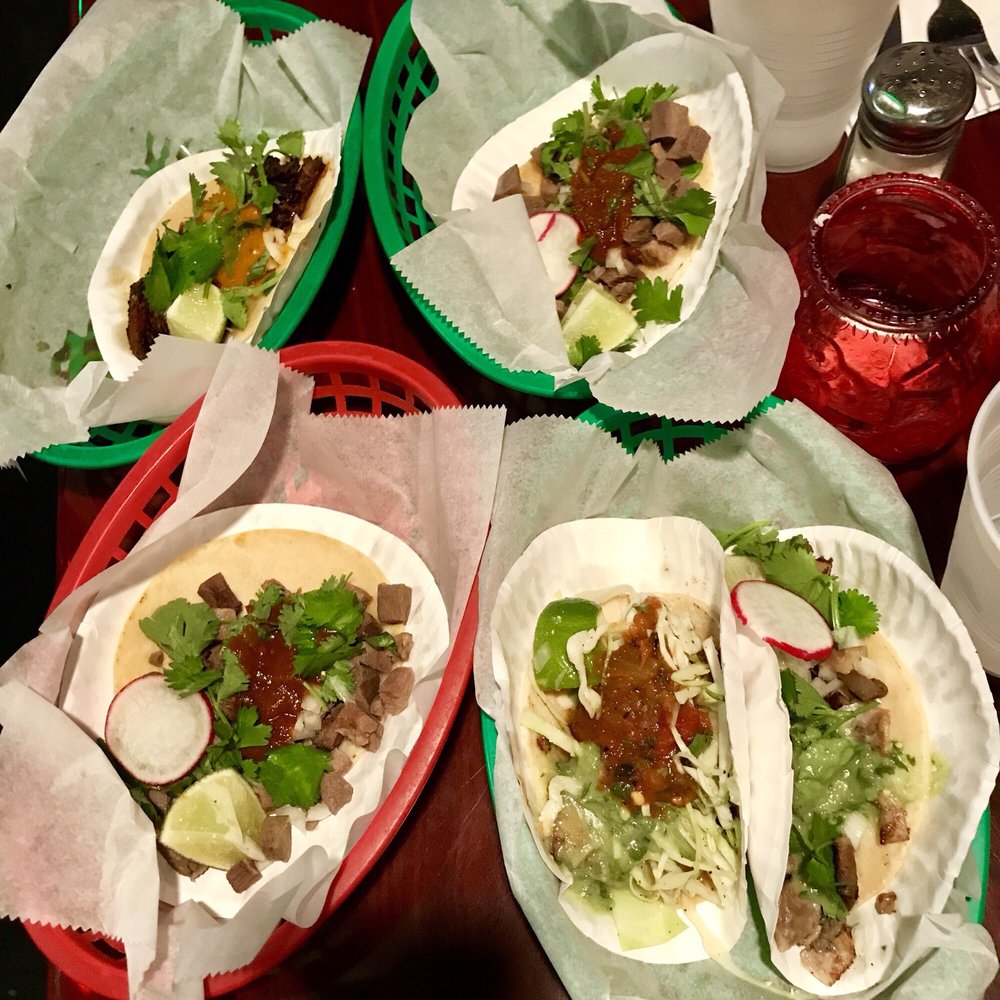 Tacos in red baskets with radish and lime