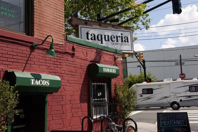 Taqueria Downtown's brick corner building with green Tacos and Tamales awnings
